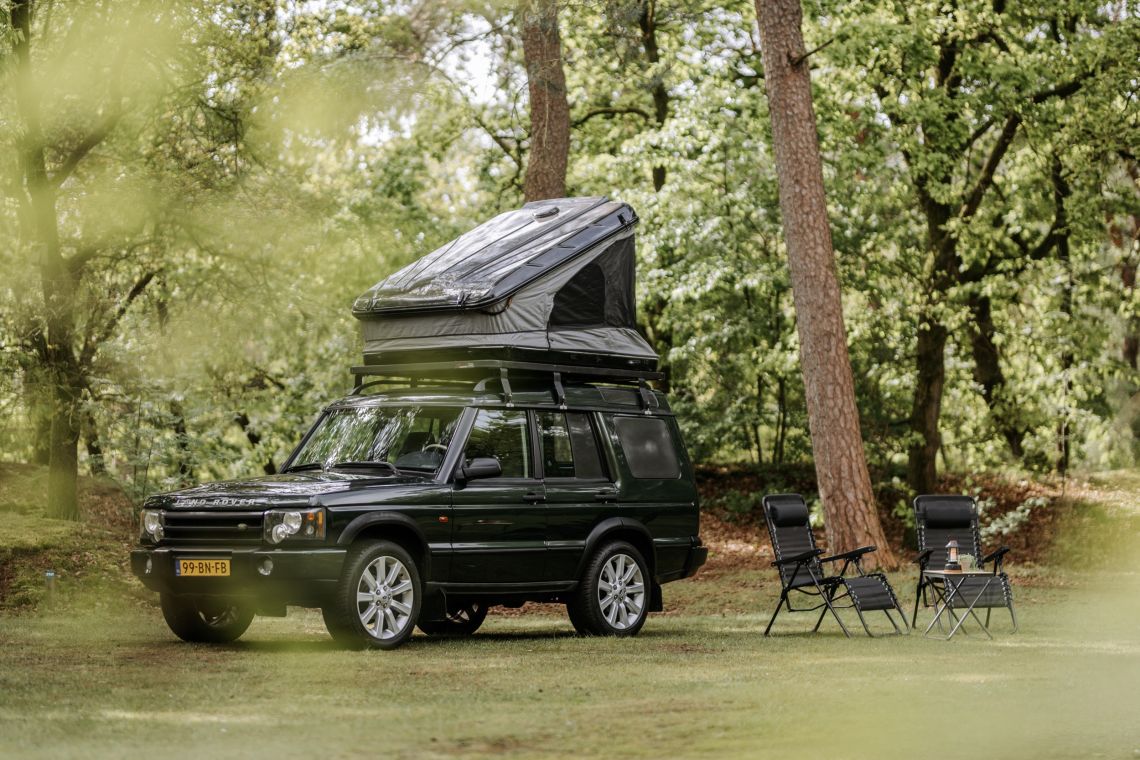 Land Rover Discovery 2 met daktent in het bos